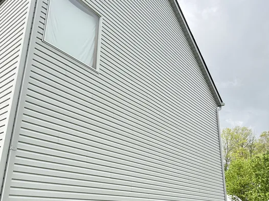 The same Medina gable after a house wash, grey siding clean and bright