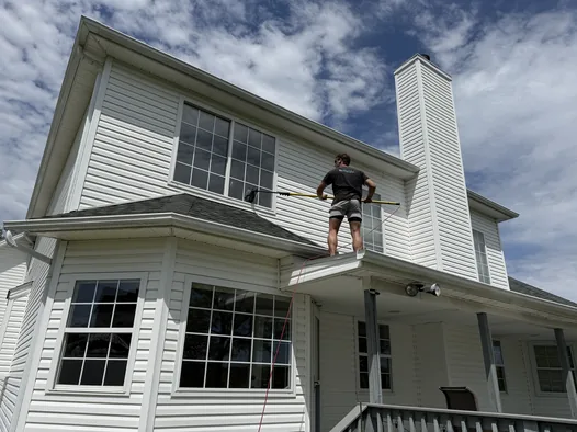 Soft washing second-story windows from the porch roof on a Medina home