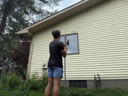 Grime Guyzz technician soft washing vinyl siding in Medina with a low-pressure wand